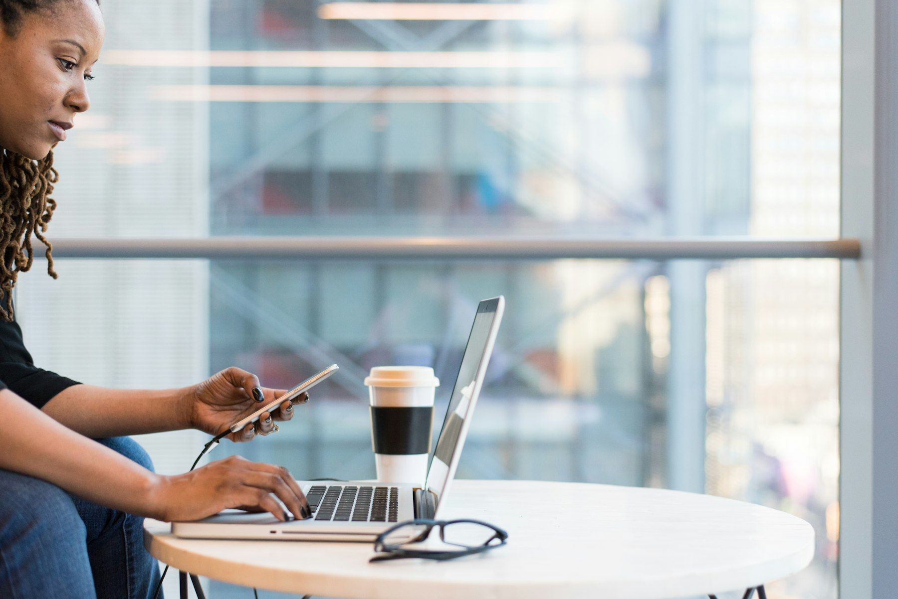 A designer checking a website on a phone and laptop